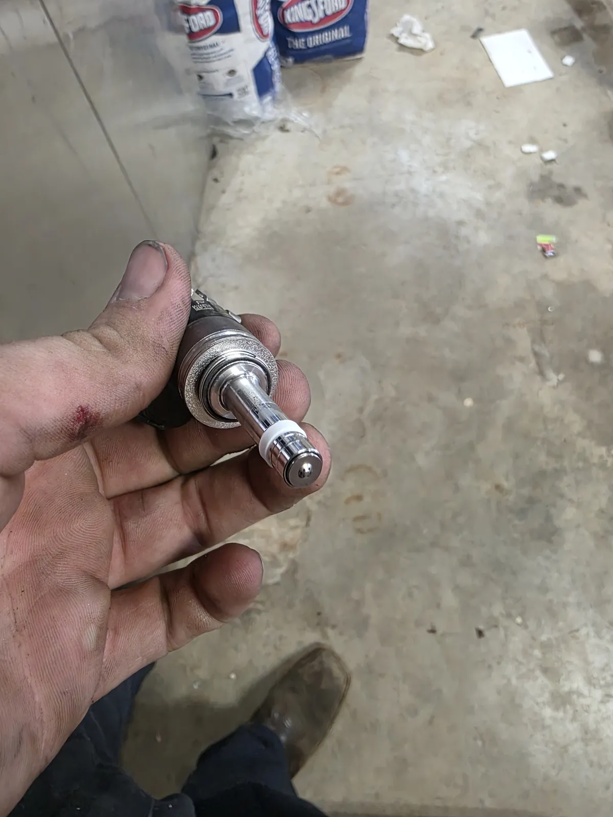 A fuel injector held in a hand, its tip and ports clean